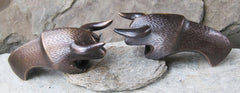 a pair of dark bronze bull shaped bottle openers