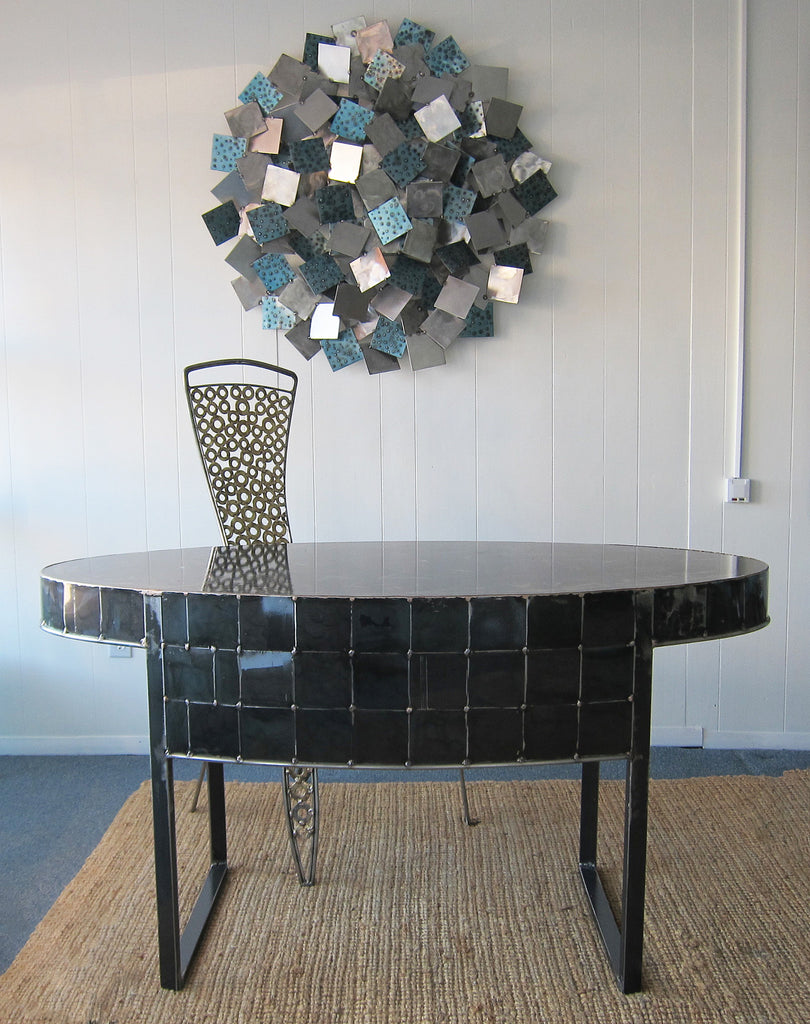 a hand made oval shaped black steel table by Peter Diepenbrock